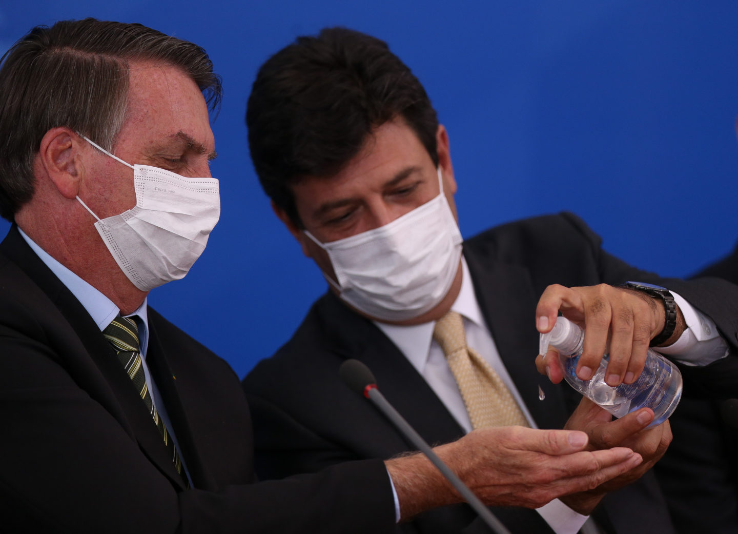 Ministro Luiz Henrique Mandetta (Saúde) aplica álcool em gel na mão do presidente Bolsonaro