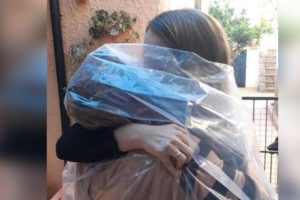 Mãe se embrulha em saco plástico para conseguir abraçar a filha