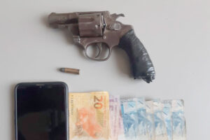 revólver calibre 32 com munição, celular e dinheiro