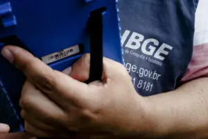 Agente segura equipamento do IBGE durante coleta do censo em São Paulo