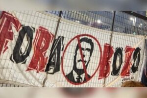 Do lado de fora do estádio, cartazes criticavam o fato de Bolsonaro ter ido assistir ao jogo