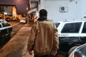 homem pega menina pelo braço em porta de escola