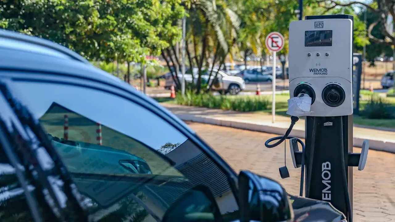 Carro elétrico abastecendo em ponto de abastecimento elétrico