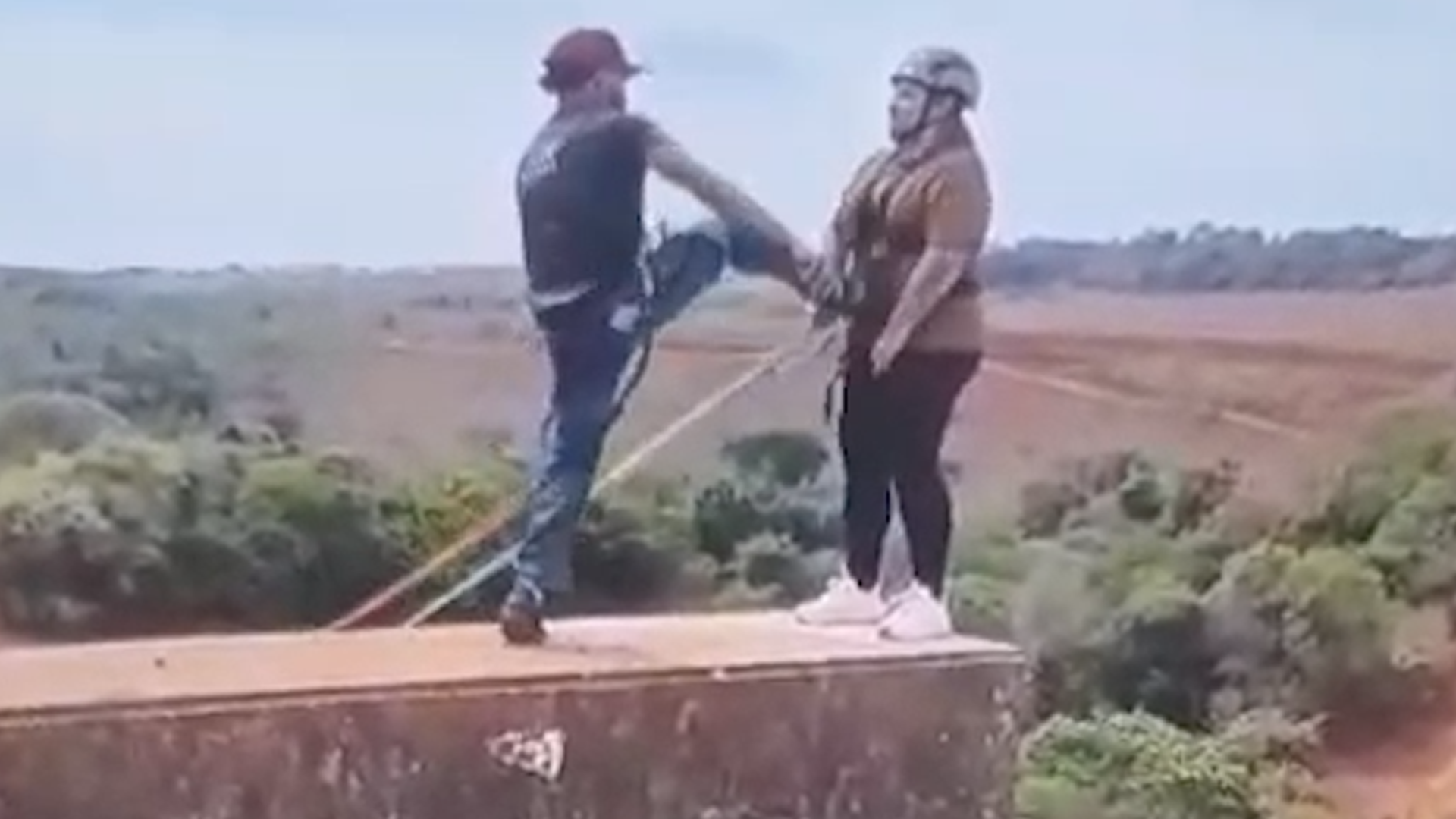 Instrutor empurra mulher com os pés para saltar da Ponte do Esqueleto, em Limeira