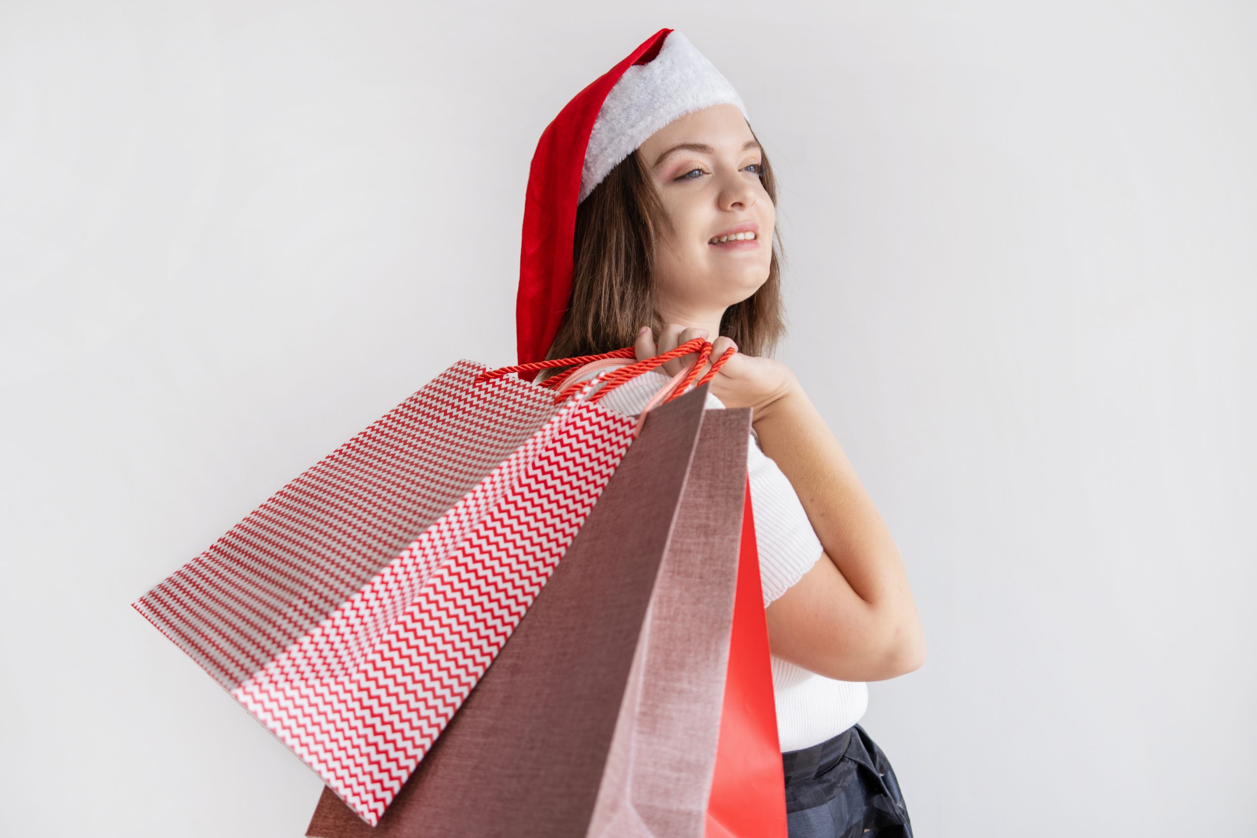 Smiling pensive lady holding shopping bags on shoulder