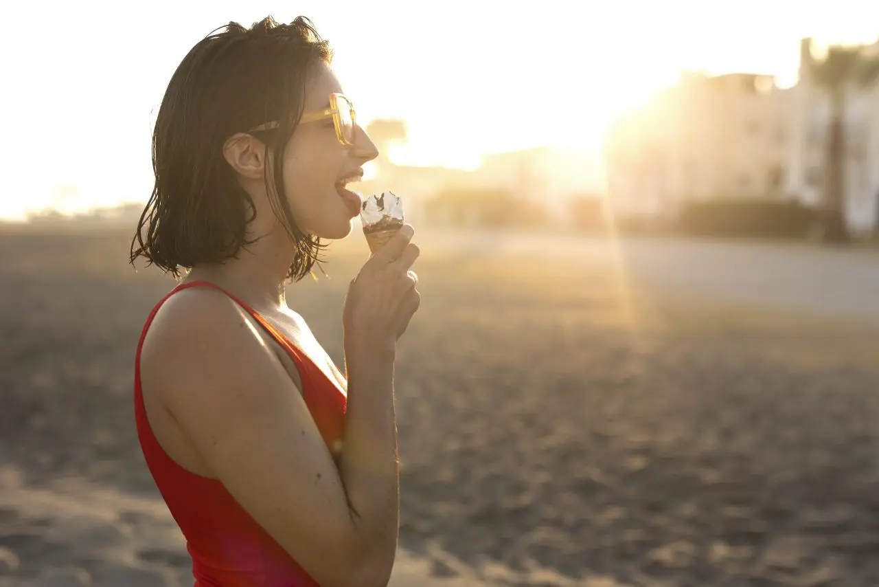 mulher-comendo-sorvete-na-vista-lateral-a-beira-mar Verão Brasileiro